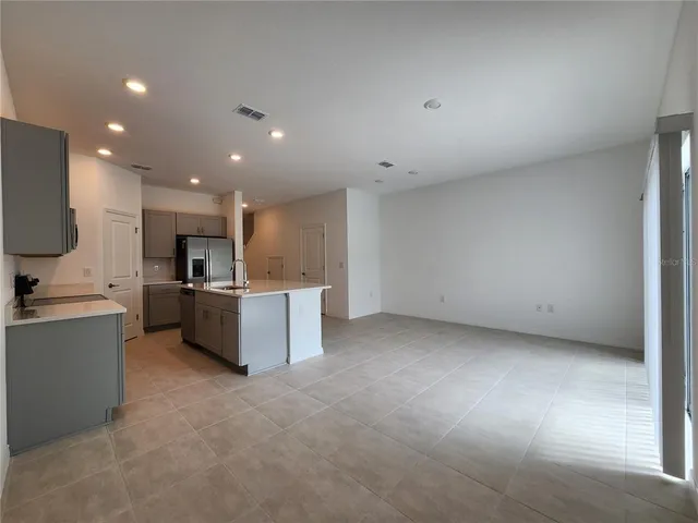 a large kitchen with a large counter top stainless steel appliances and cabinets