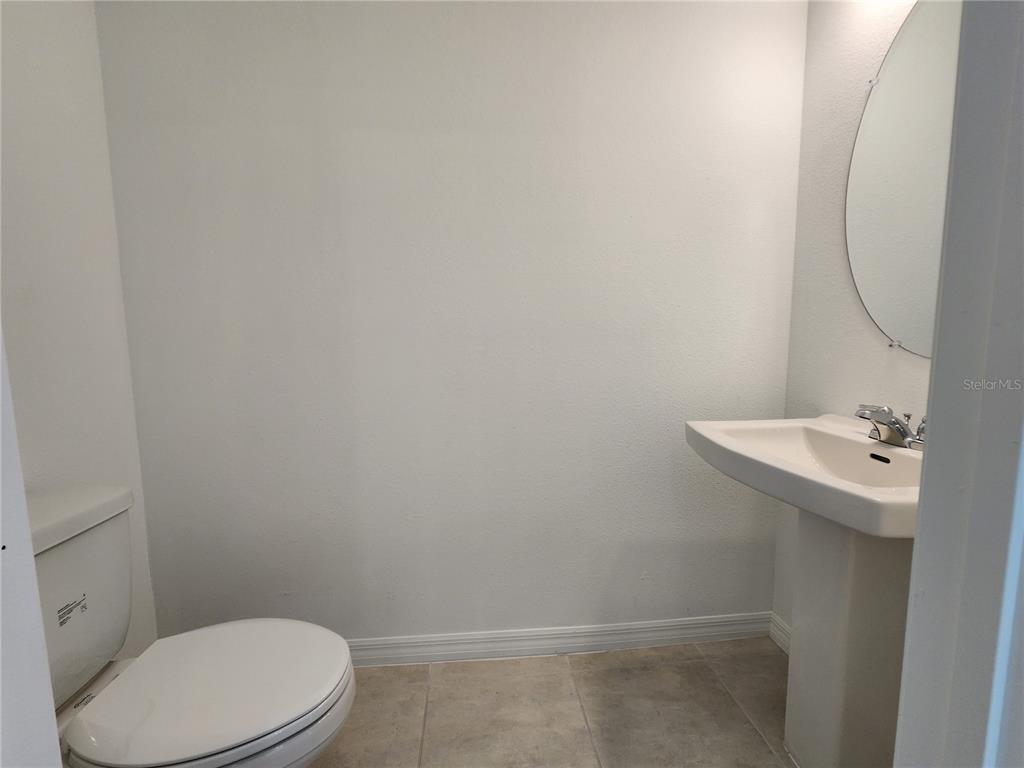 2620 Penguin Boulevard Davenport, FL 33837 - Photo 4 of 14 a bathroom with a sink a toilet and a mirror