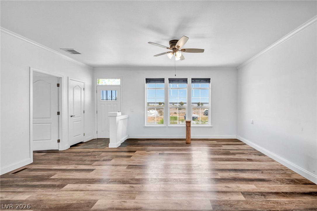 225 California Street Searchlight, NV 89046 - Photo 17 of 64 A welcoming entry area boasts rich wood flooring and a refreshing ceiling fan, complemented by ample natural light from multiple windows.