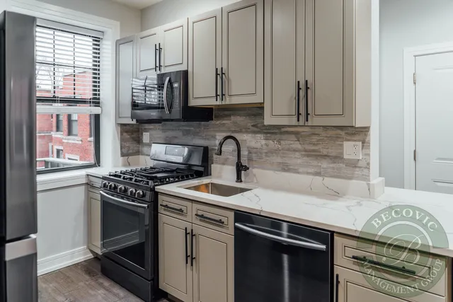 a kitchen with granite countertop a stove sink and cabinets