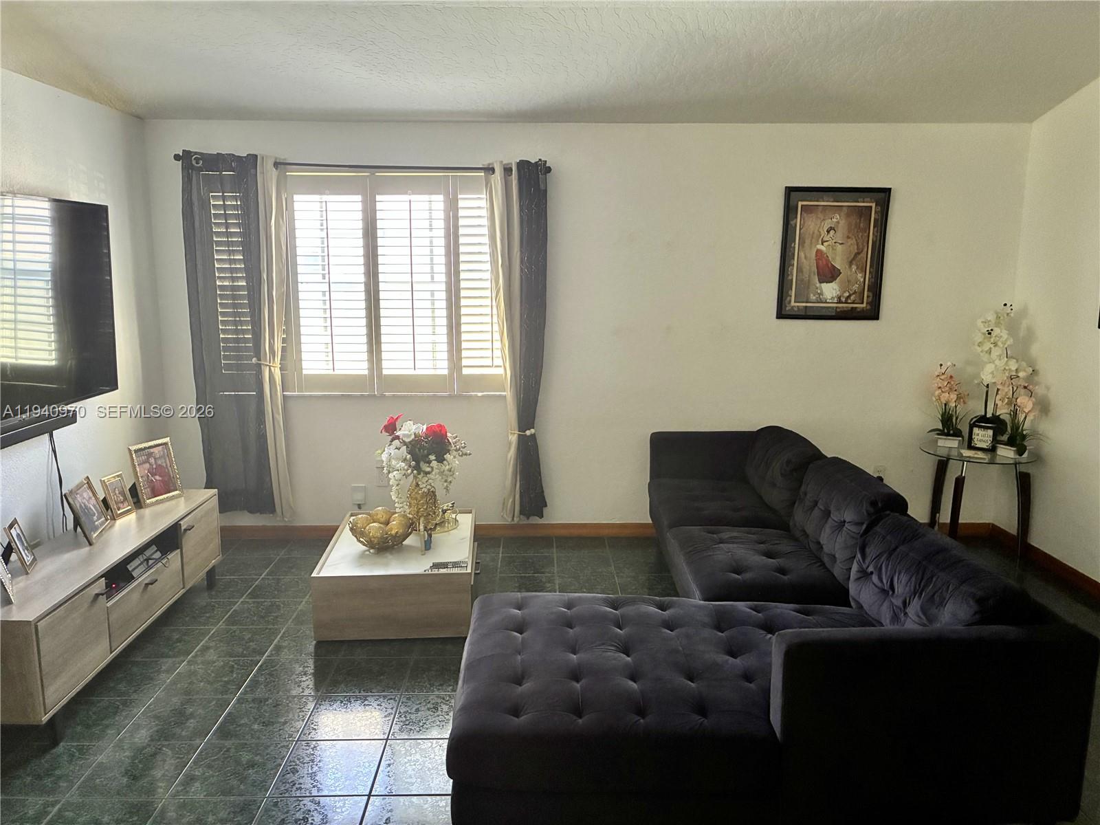 8564 Southwest 210th Terrace Cutler Bay, FL 33189 - Photo 3 of 18 a living room with furniture and a flat screen tv