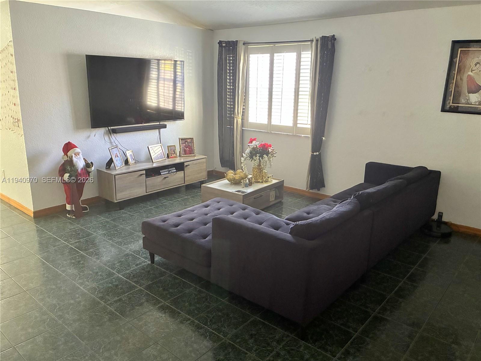 8564 Southwest 210th Terrace Cutler Bay, FL 33189 - Photo 5 of 18 a living room with furniture and a flat screen tv