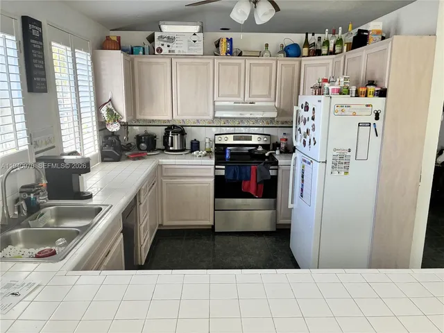 a kitchen with refrigerator and cabinets