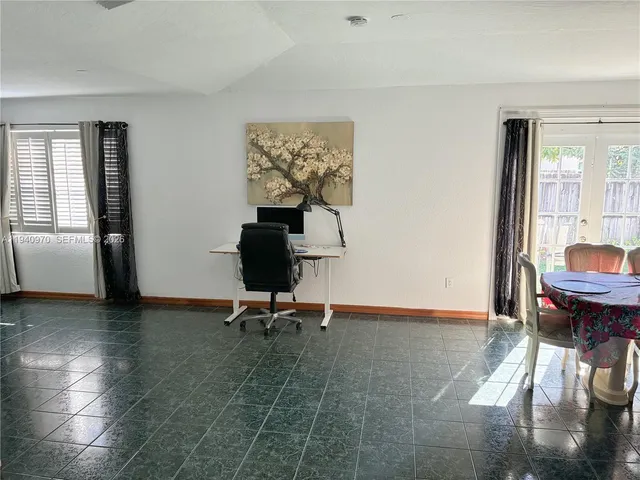 a view of a workspace with furniture and a window