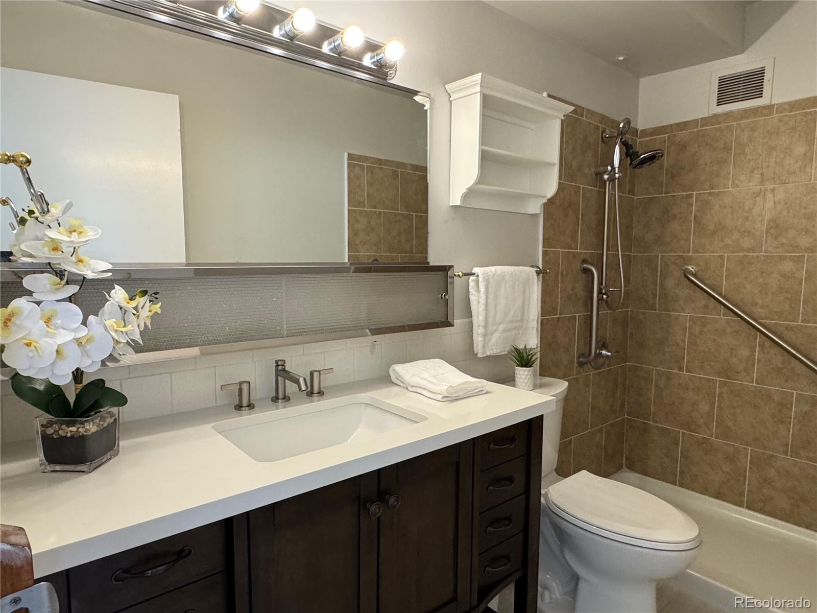 755 South Alton Way, Unit 12C Denver, CO 80247 - Photo 6 of 12 a bathroom with a sink a toilet and shower