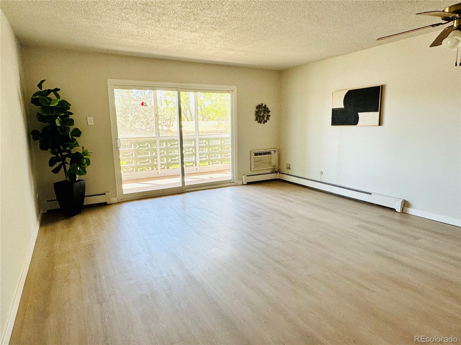 755 South Alton Way, Unit 12C Denver, CO 80247 - Photo 7 of 12 wooden floor in an empty room with a window