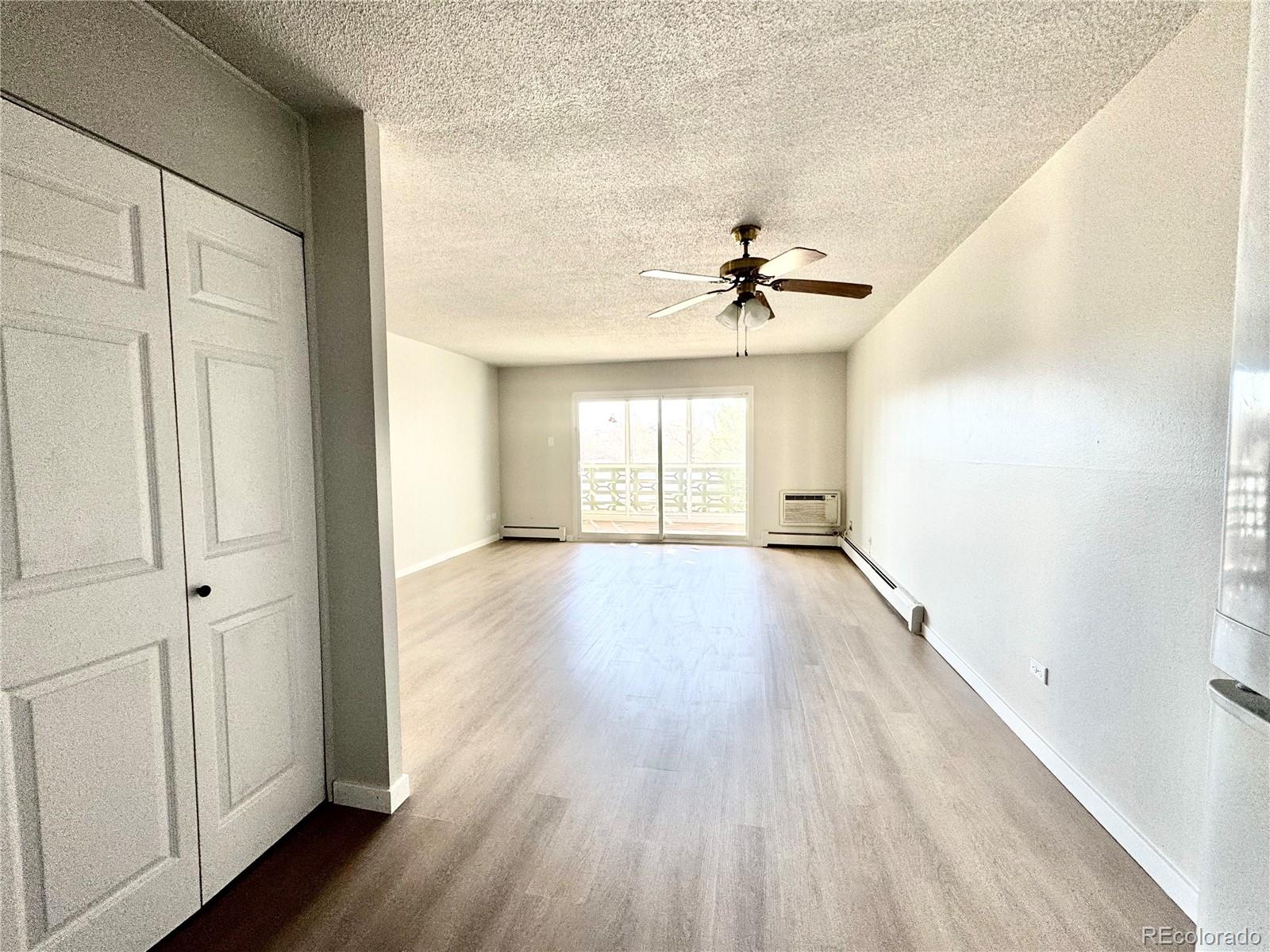 755 South Alton Way, Unit 12C Denver, CO 80247 - Photo 8 of 12 wooden floor in an empty room with a window
