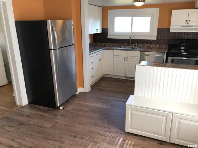 a kitchen with granite countertop wooden floors and stainless steel appliances