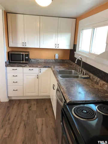 a utility room with wooden floor washer and dryer