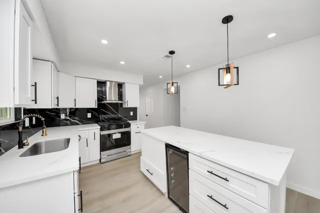 a kitchen that has a sink a stove and a table