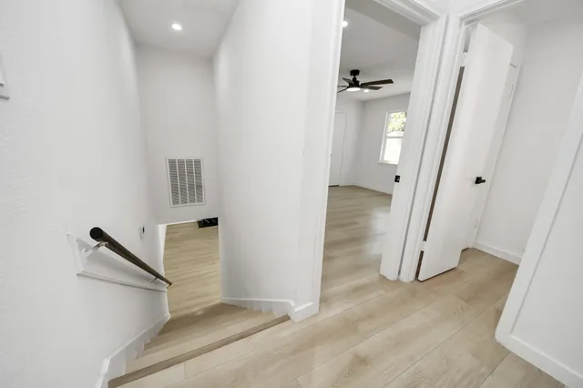 a view of a big room with wooden floor and windows