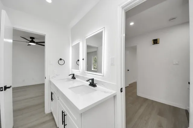 a spacious bathroom with a granite countertop sink and a mirror