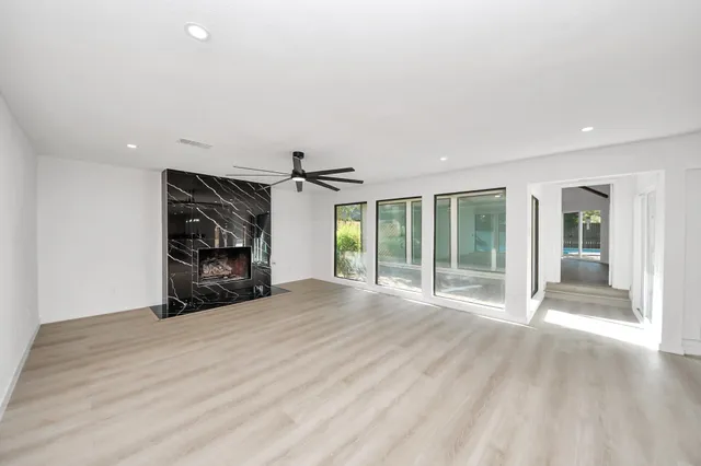 a view of an empty room with a window and a fireplace