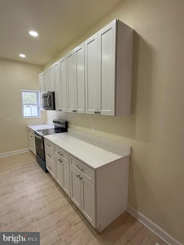 a kitchen with stainless steel appliances a sink stove and cabinets