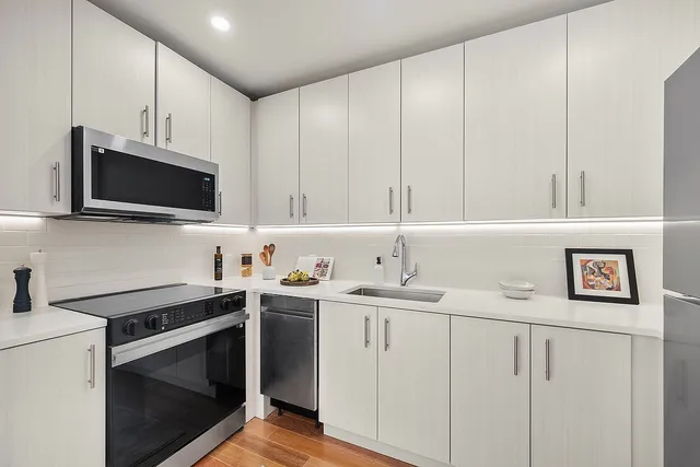 a kitchen with a sink a refrigerator and cabinets