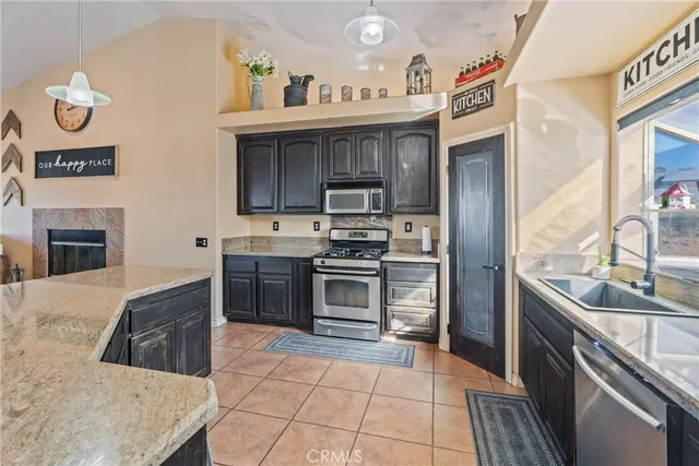 a kitchen with stainless steel appliances granite countertop a sink a refrigerator and a stove
