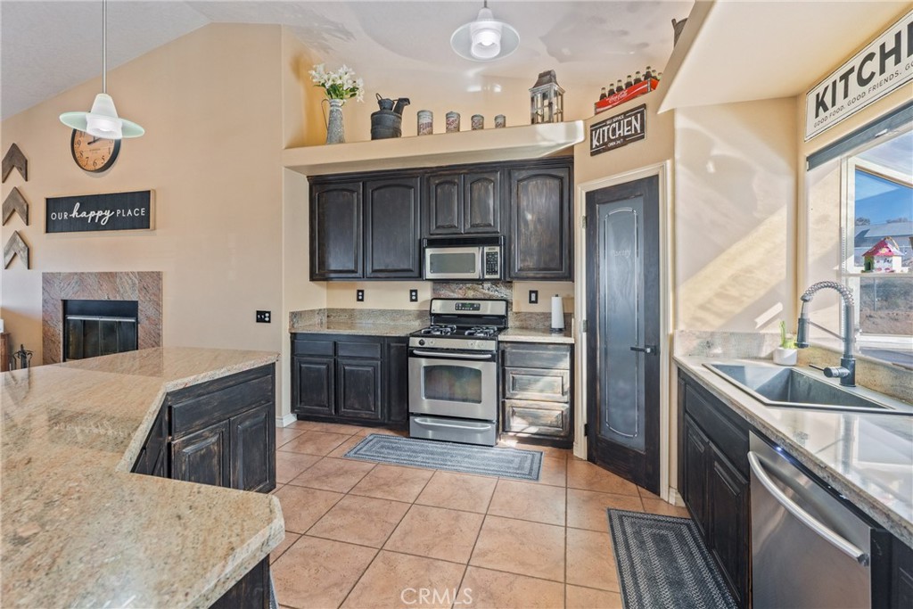 23053 Roundup Way Apple Valley, CA 92308 - Photo 13 of 46 a kitchen with stainless steel appliances granite countertop a stove and a sink
