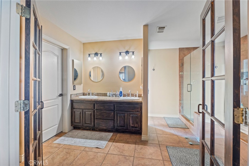 23053 Roundup Way Apple Valley, CA 92308 - Photo 23 of 46 a spacious bathroom with a mirror and a bath tub