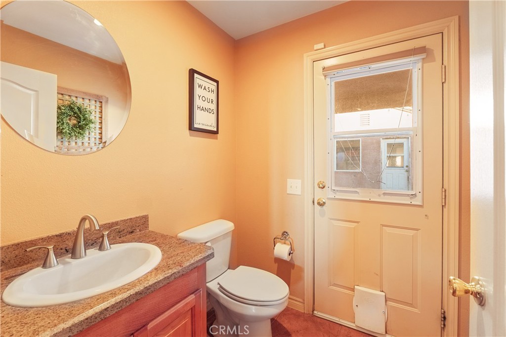 23053 Roundup Way Apple Valley, CA 92308 - Photo 34 of 46 a bathroom with a sink a mirror and a toilet