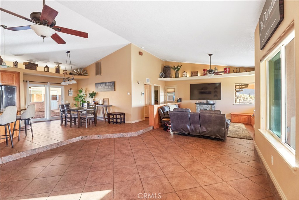 23053 Roundup Way Apple Valley, CA 92308 - Photo 10 of 46 a living room with furniture a dining table and chairs with a large window