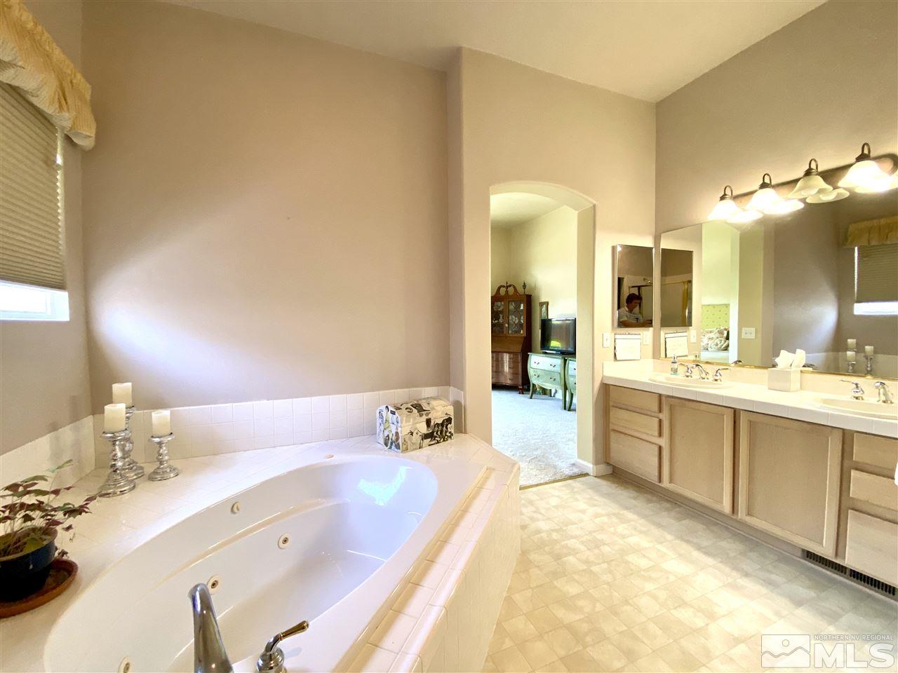 1486 Amston Road Reno, NV 89511 - Photo 11 of 18 a spacious bathroom with a tub sink and mirror