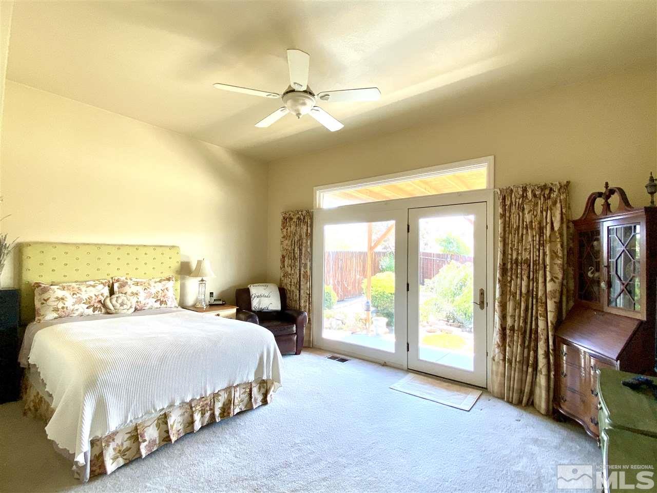 1486 Amston Road Reno, NV 89511 - Photo 12 of 18 a bedroom with a large bed and a flat tv screen on dresser