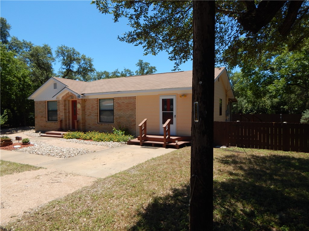 a view of a house with backyard and a tree