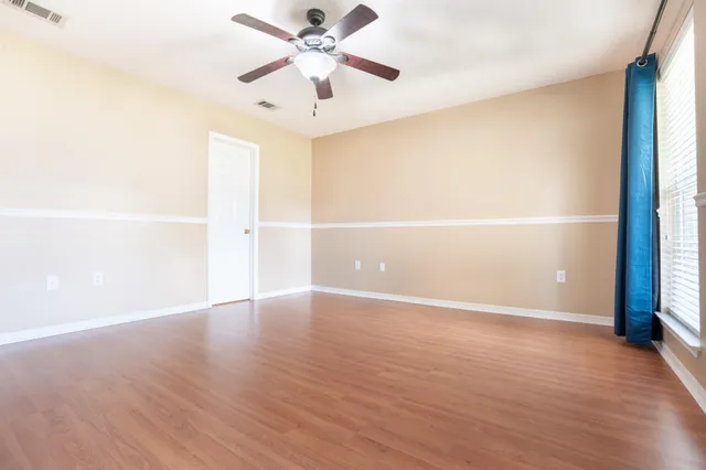 a view of an empty room with wooden floor