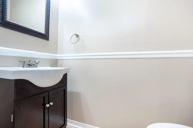 a bathroom with a sink vanity and a toilet
