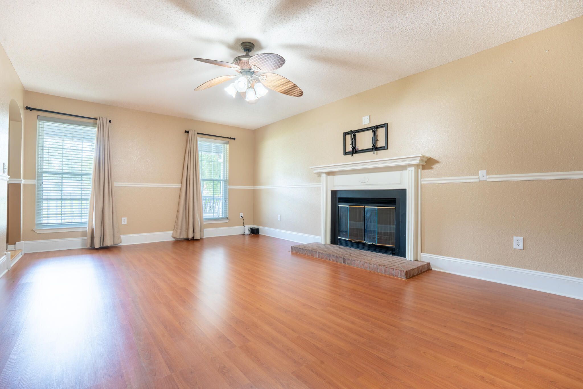 2786 Willow Bend Court Crestview, FL 32539 - Photo 8 of 32 a view of an empty room with wooden floor fireplace and a window