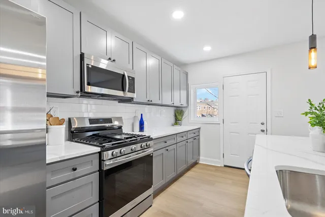 a kitchen with granite countertop white cabinets and stainless steel appliances