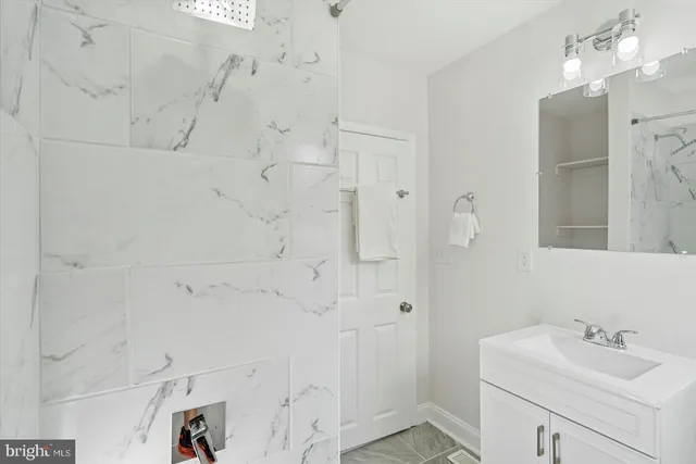 a bathroom with a sink mirror and shower