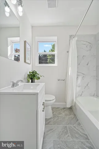a bath room with a toilet a sink and a bath tub