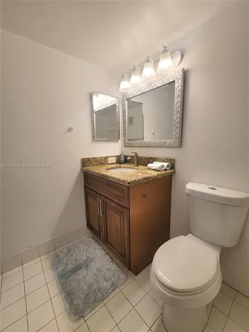 a bathroom with a granite countertop sink a toilet and bathtub