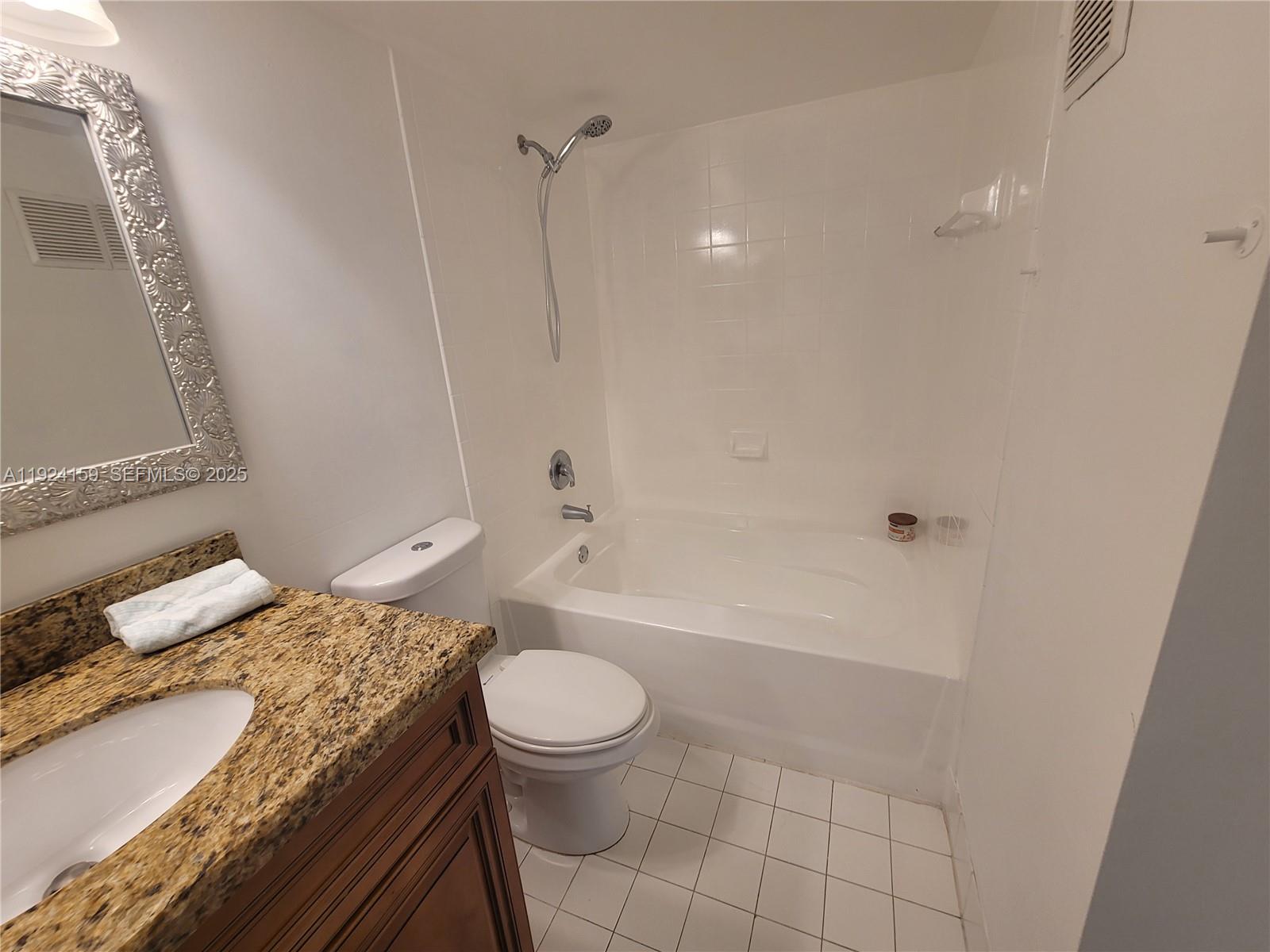 2133 Renaissance Boulevard, Unit 306 Miramar, FL 33025 - Photo 21 of 32 a bathroom with a granite countertop sink a toilet and bathtub