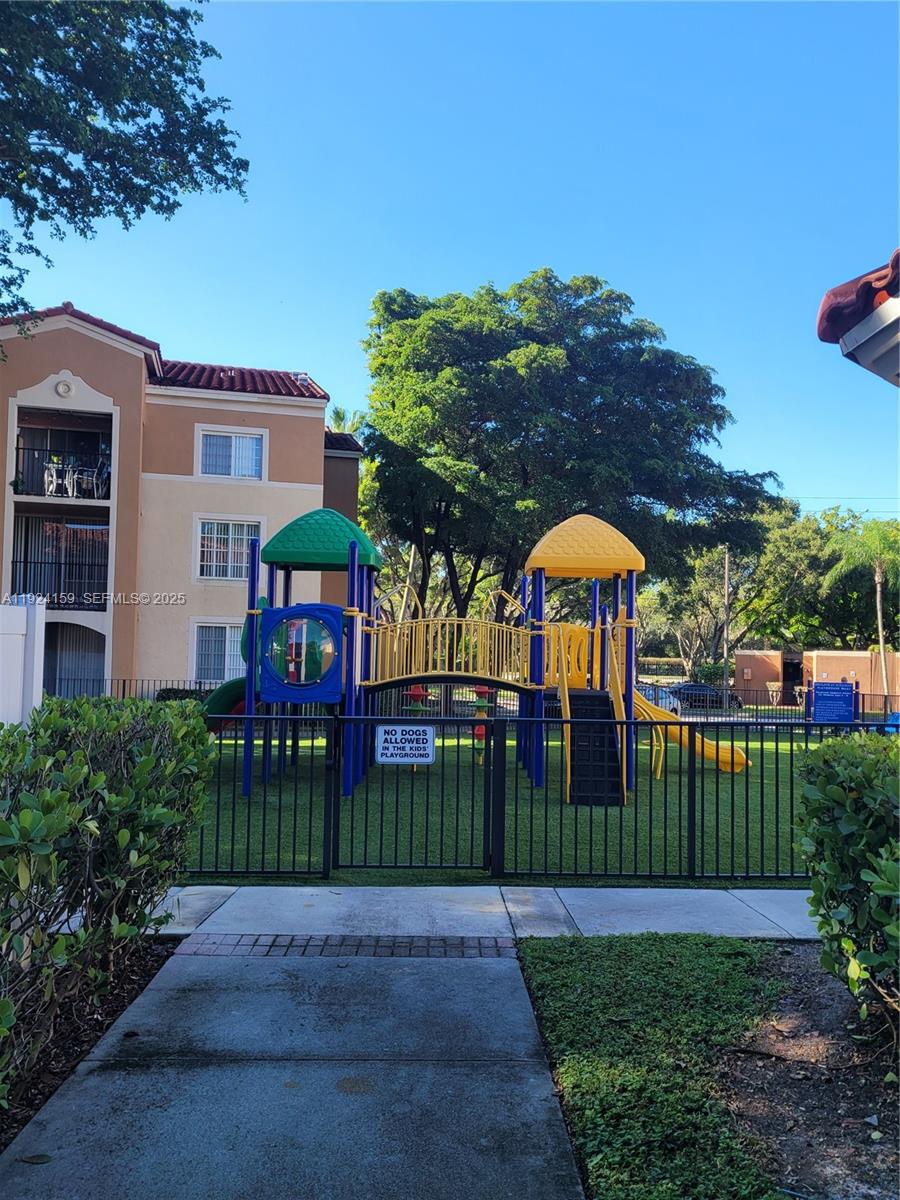 2133 Renaissance Boulevard, Unit 306 Miramar, FL 33025 - Photo 26 of 32 a view of a brick house with a yard and plants