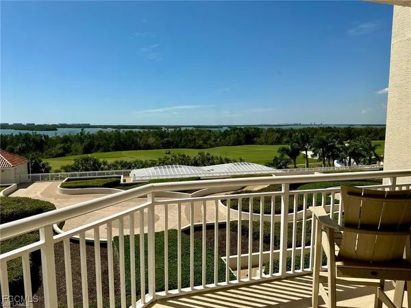 a view of a balcony with wooden floor and fence
