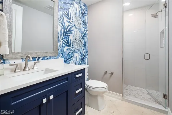 a bathroom with a granite countertop sink toilet and shower