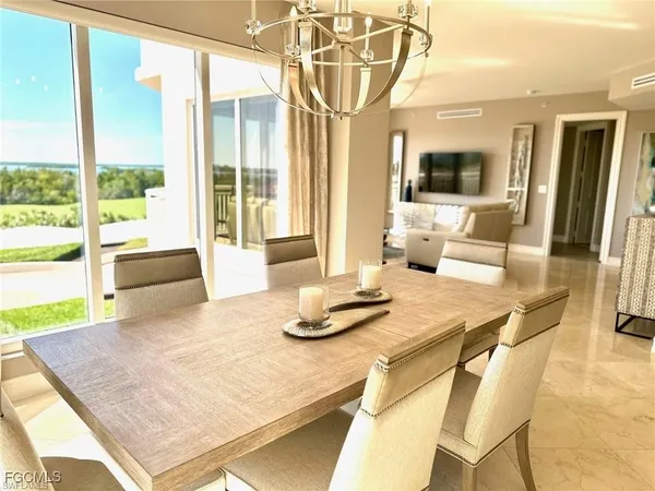 a dining room with a table and chairs next to a window