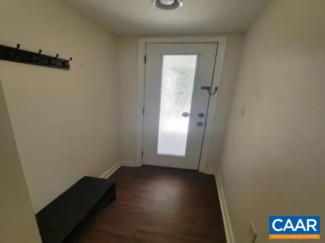 an empty room with wooden floor and a window