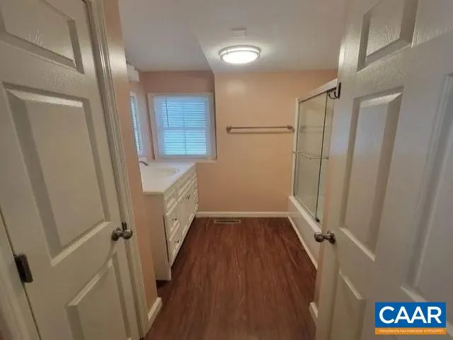 a view of hallway with stairs and wooden floor