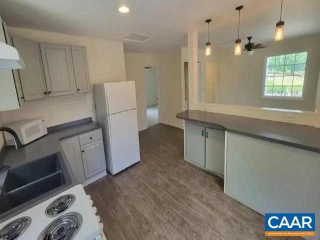 a kitchen with a refrigerator and a stove top oven