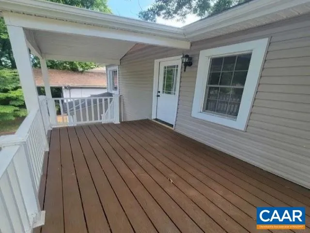 a view of backyard with a deck and wooden floor