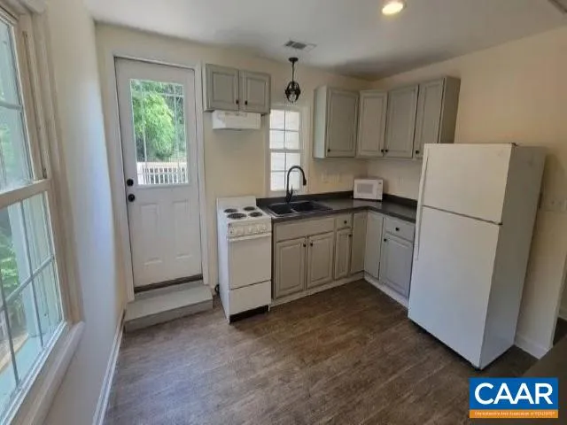 a kitchen with a refrigerator a stove a sink and a window