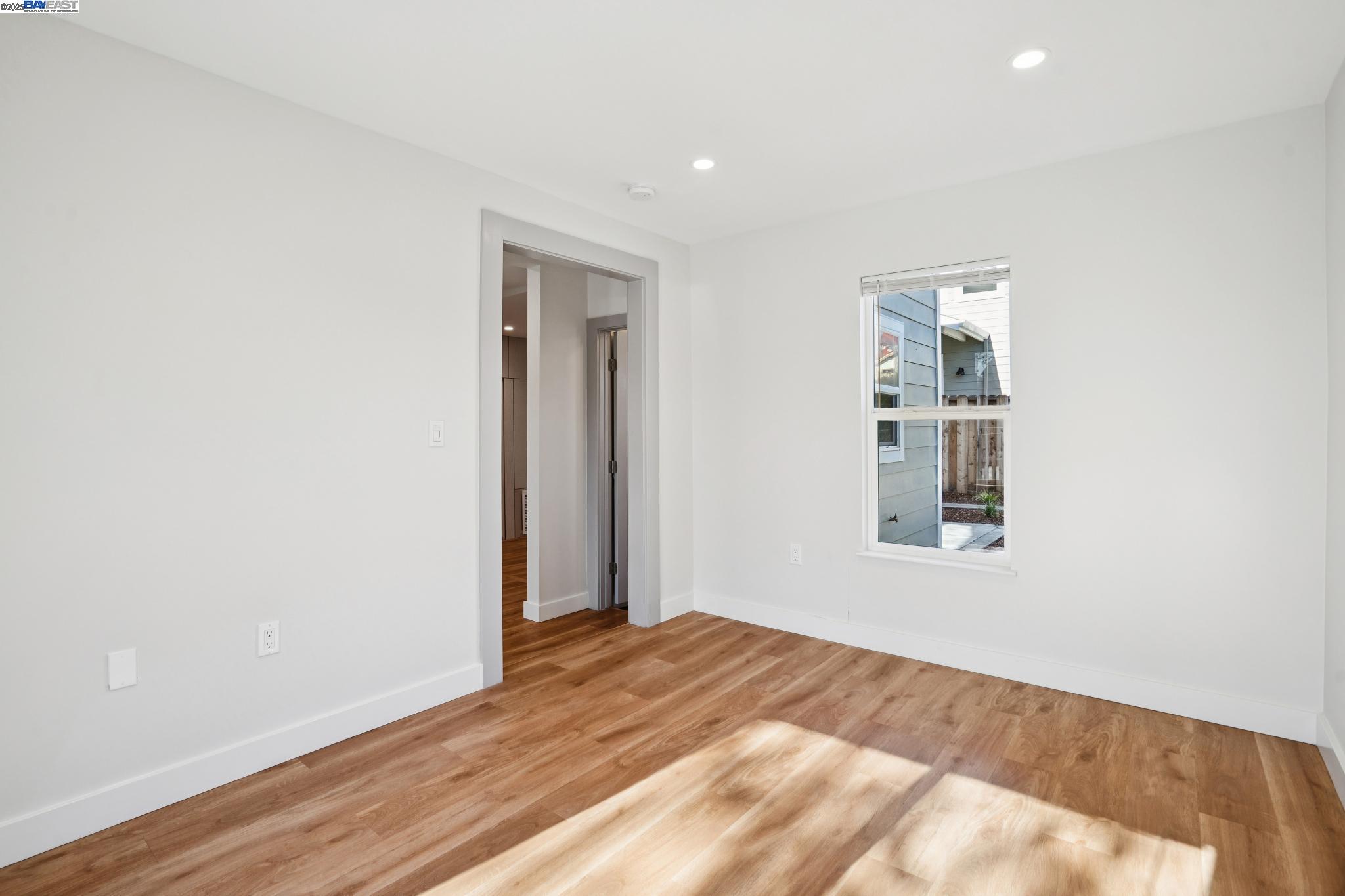 882 61st Street Oakland, CA 94608 - Photo 11 of 51 a view of empty room with wooden floor and fan