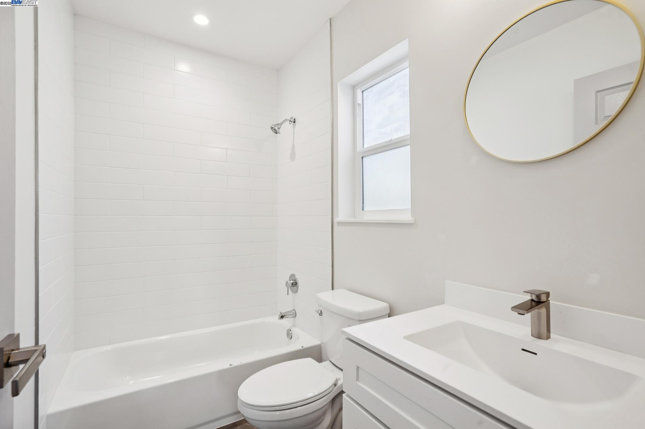882 61st Street Oakland, CA 94608 - Photo 13 of 51 a bathroom with a toilet a sink a mirror and bathtub