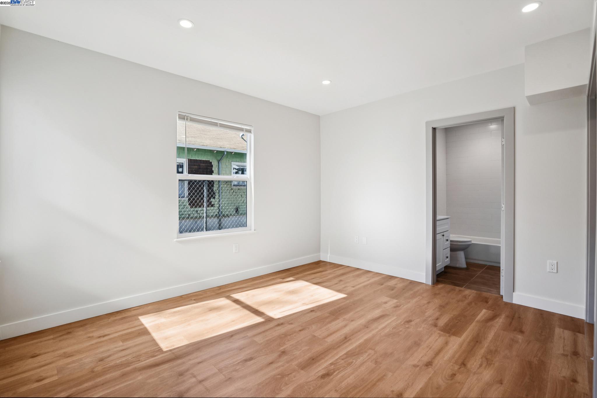 882 61st Street Oakland, CA 94608 - Photo 15 of 51 an empty room with wooden floor and a window