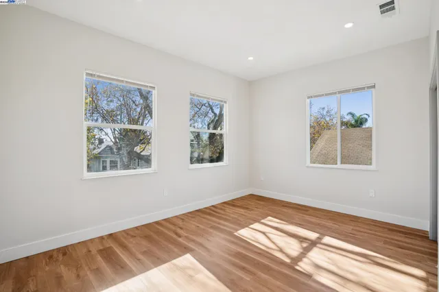 a view of a bedroom with wooden floor and window
