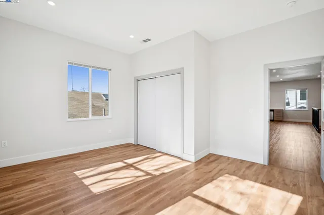 a view of a room with wooden floor and a window