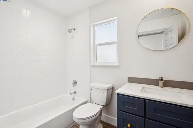 a bathroom with a toilet a sink a mirror and bathtub